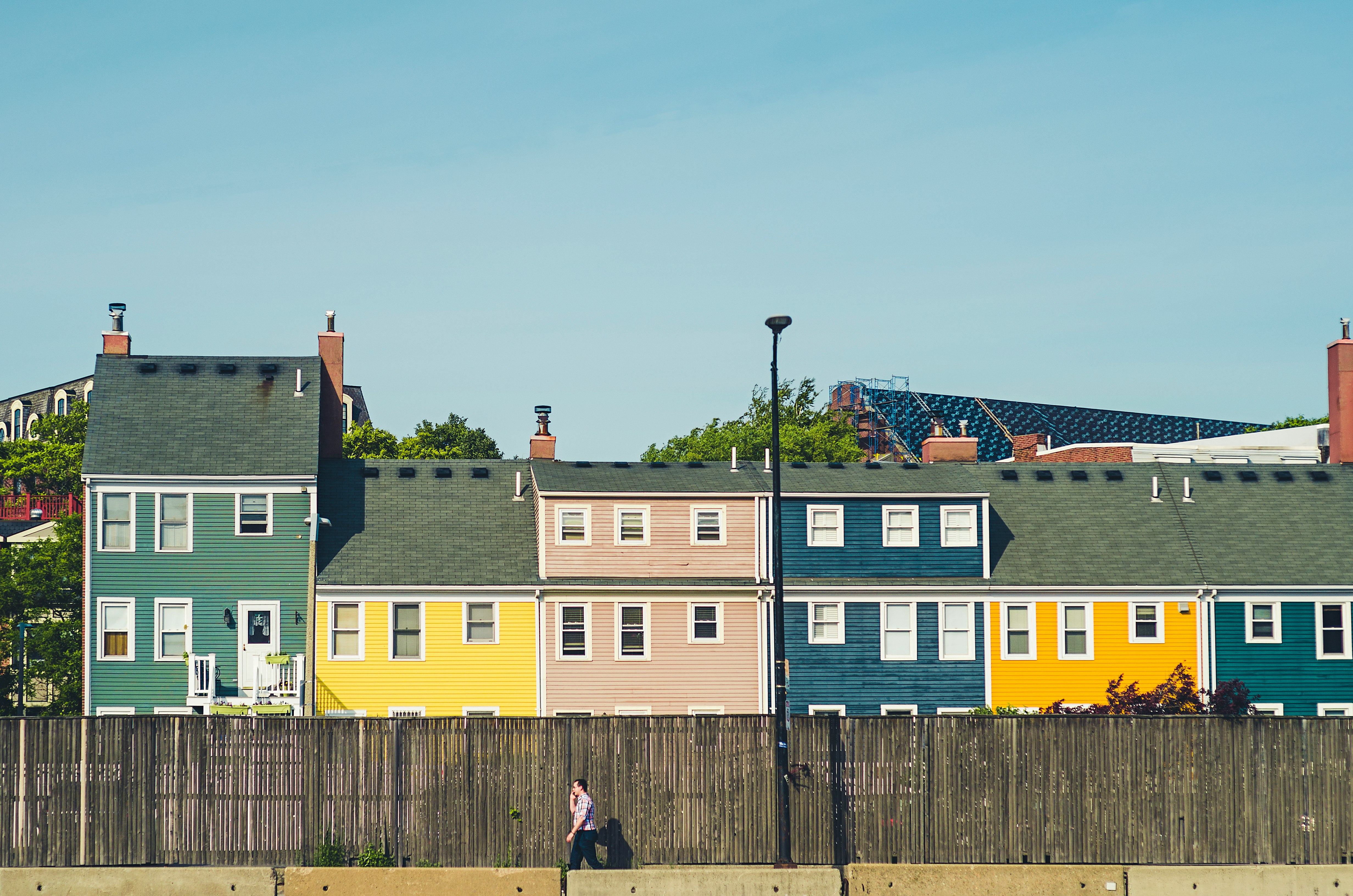 man walking beside multicolored apartments